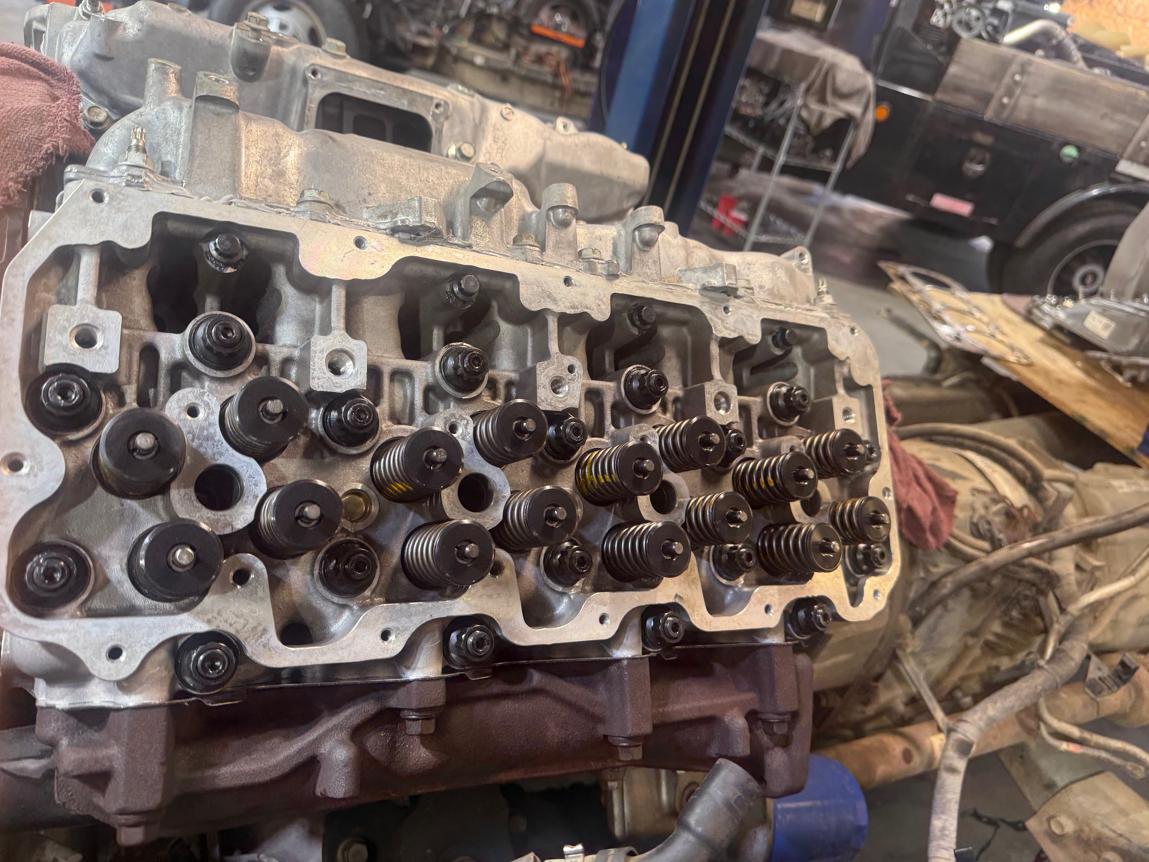 Close-up of an aluminum engine cylinder head with exposed valve springs and retainers.